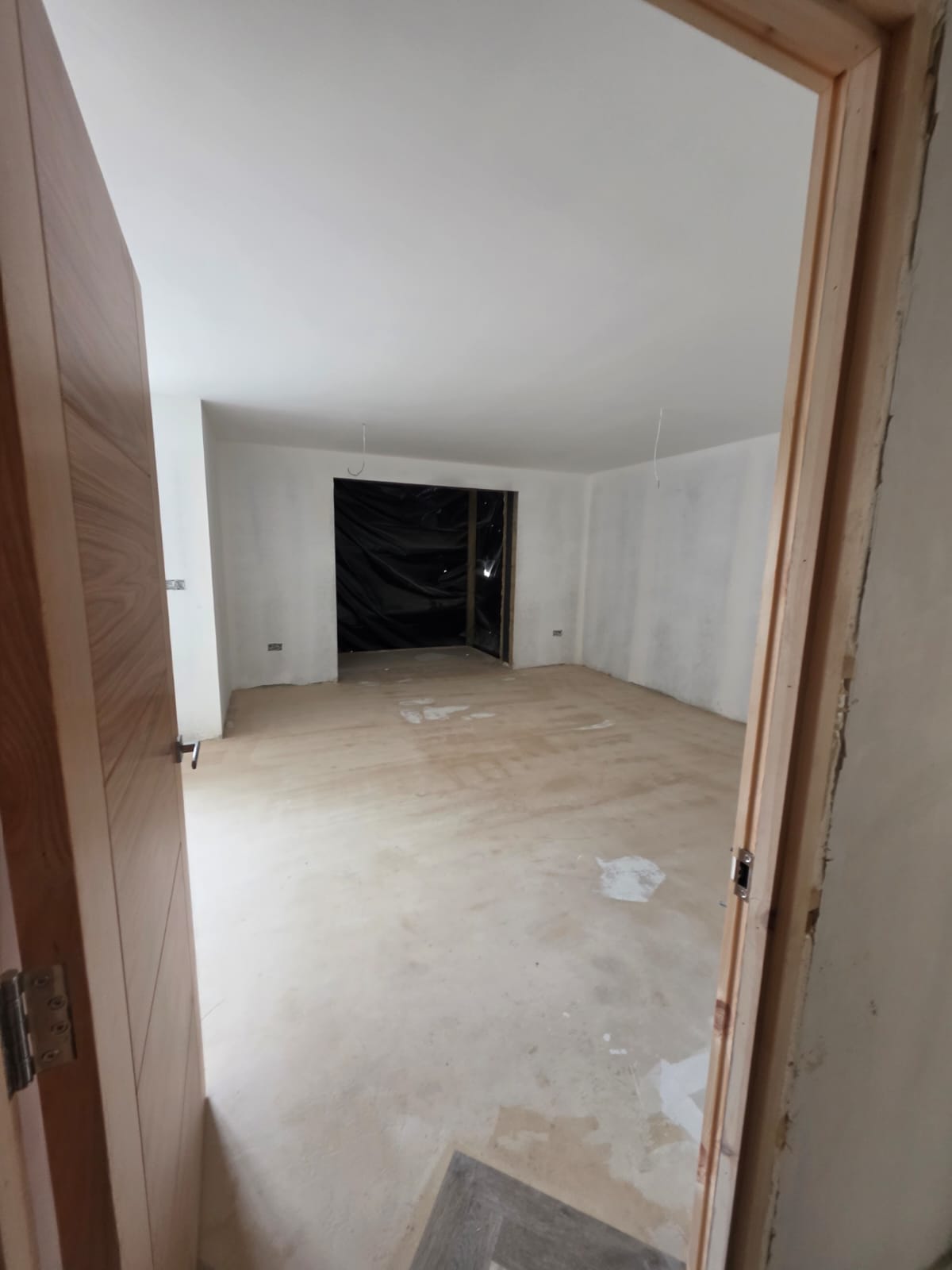 Internal oak veneer door installation and prepared open-plan floor in Southend-on-Sea refurbishment by DWELLUX