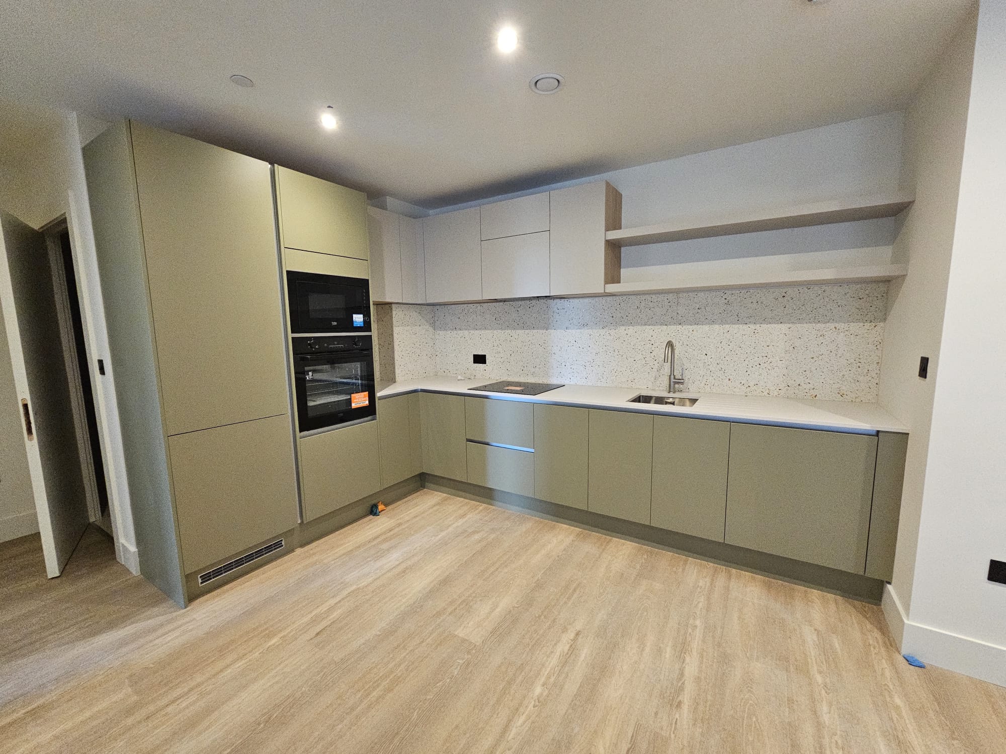 Detailed view of kitchen cabinetry installation and appliance housing in Surrey Quays residential apartment