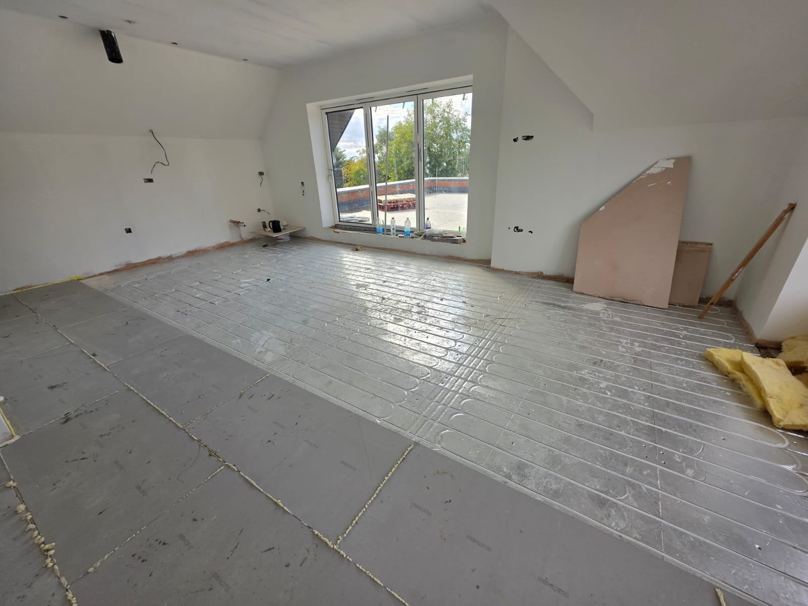 Upper floor room with underfloor heating pipework set into routed insulation panels in Southend-on-Sea by DWELLUX