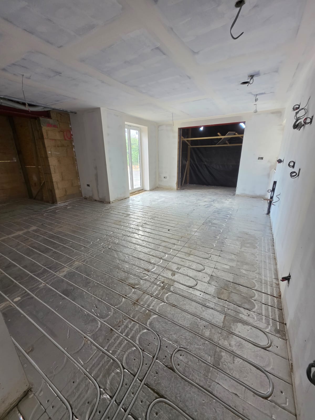 Underfloor heating pipework loops set into thermal insulation panels across full ground floor open-plan layout in Southend-on-Sea