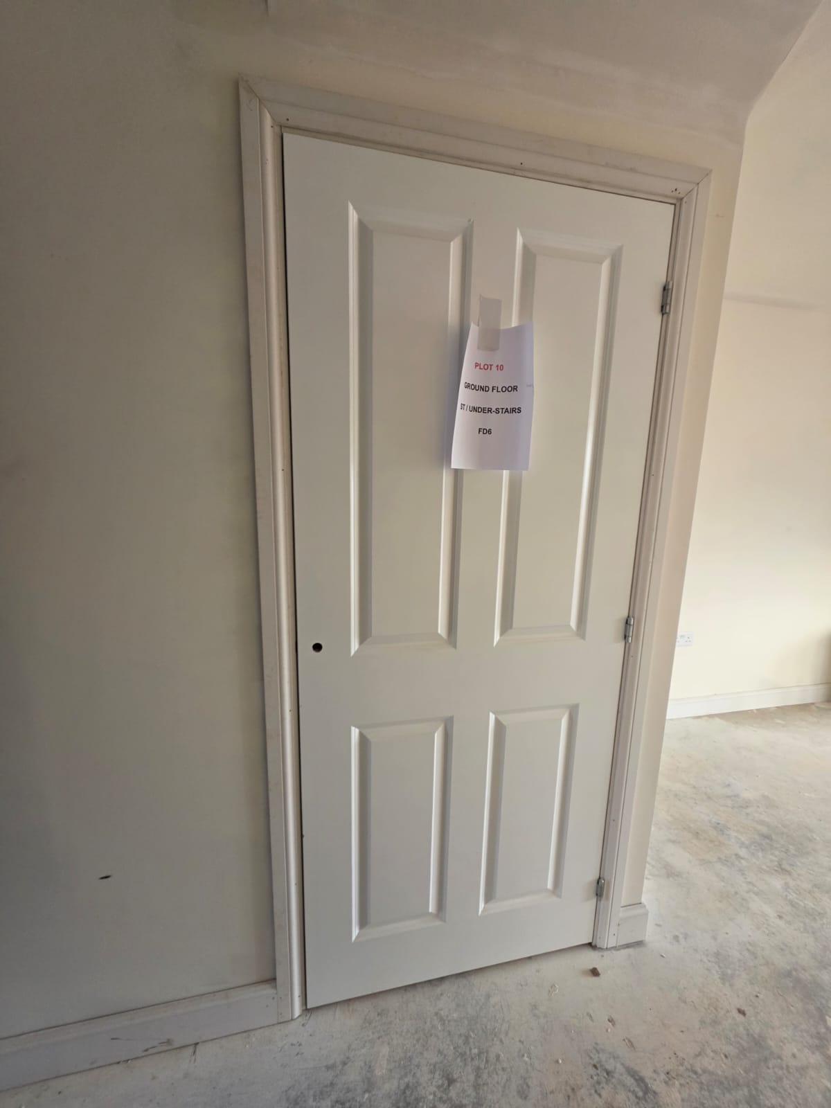 Plot 10 ground floor under-stairs fire door FD6 fitted with precision architrave in Harlow development by DWELLUX