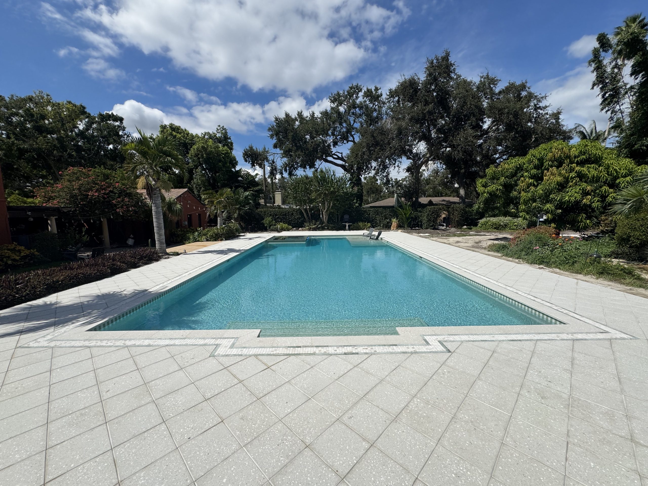 After historic pool reconstruction — pristine azure water, mosaic coping inlay and custom deck