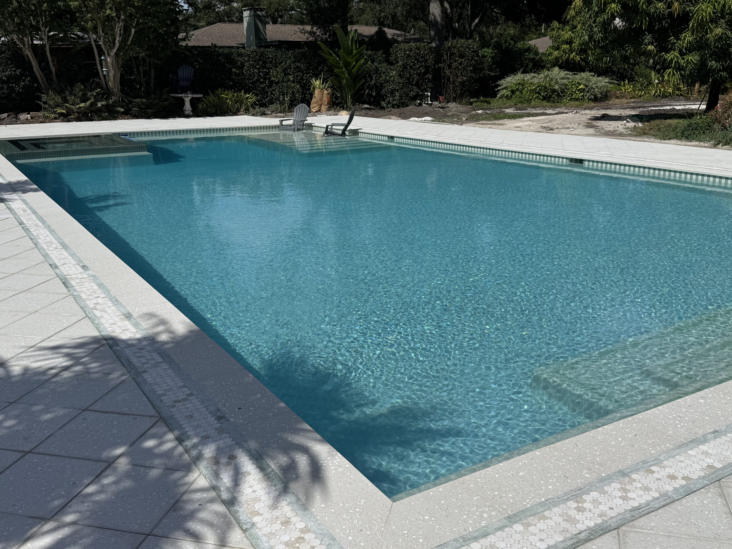 Restored pool showing mosaic circular border inlay, steps, and azure water