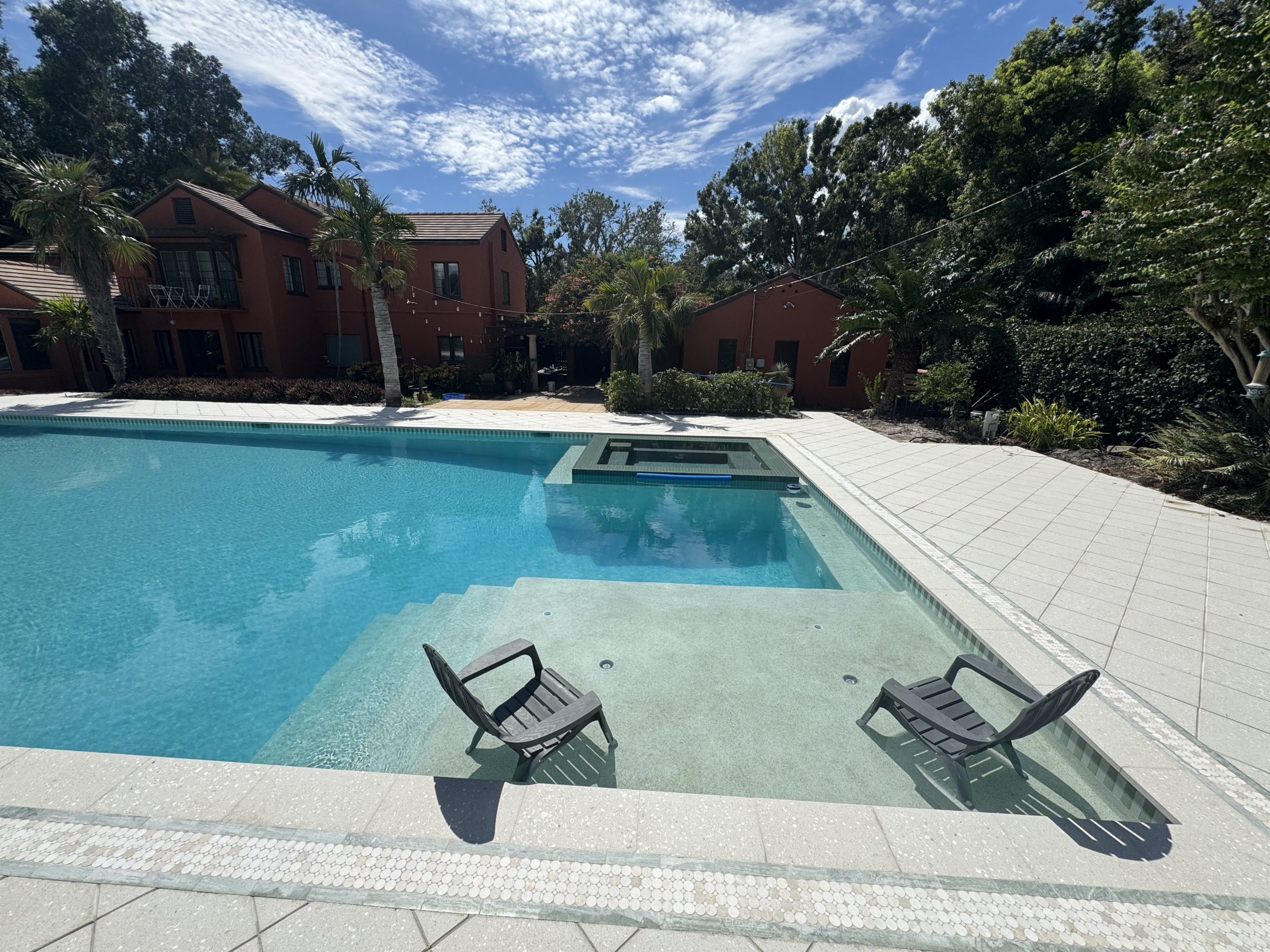 Tanning ledge sun shelf with in-water loungers and Mediterranean villa in background