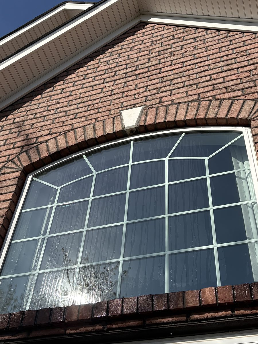 Arched window with water spots and grime before cleaning