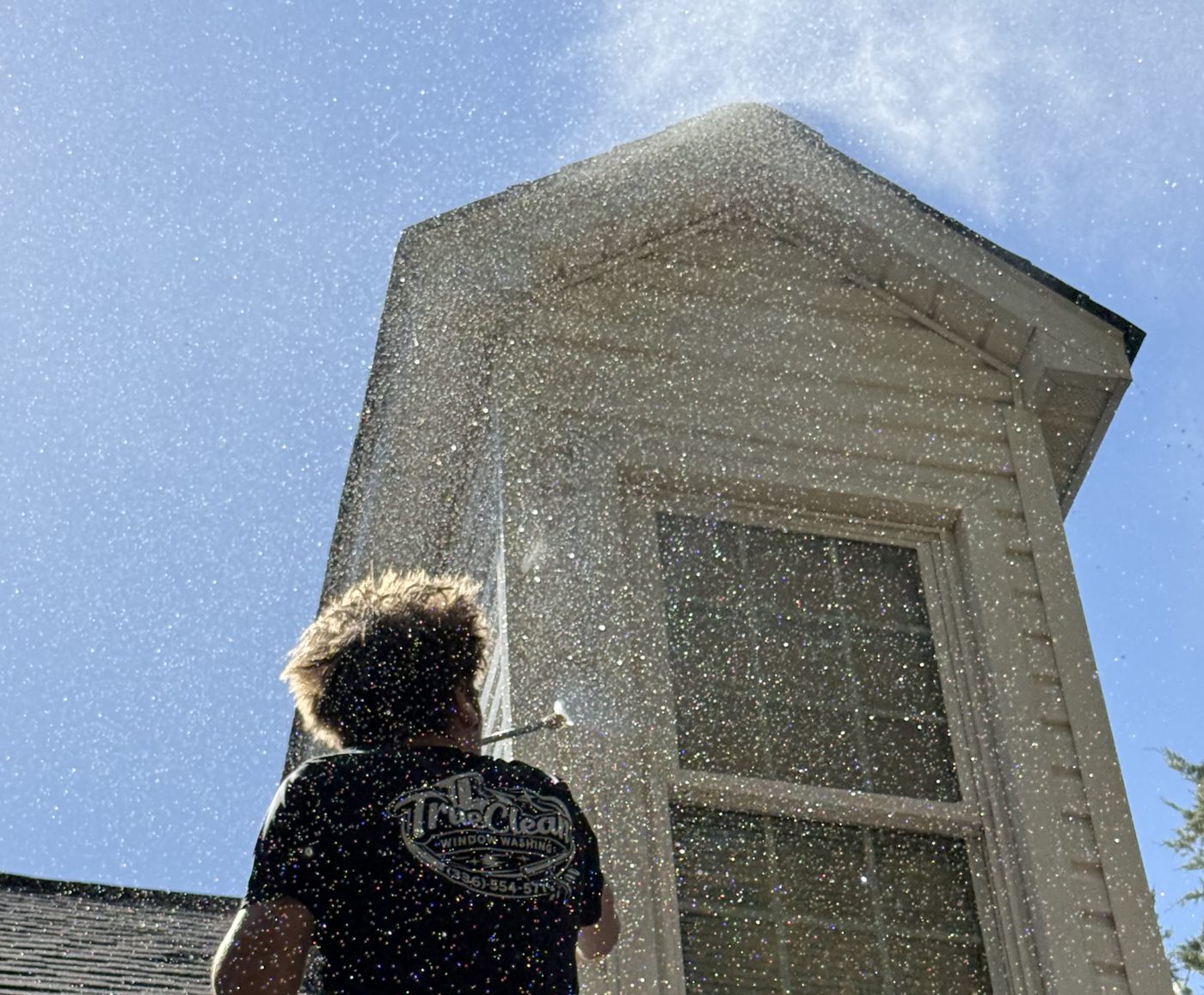 TrueClean owner washing a second story dormer window in Greensboro