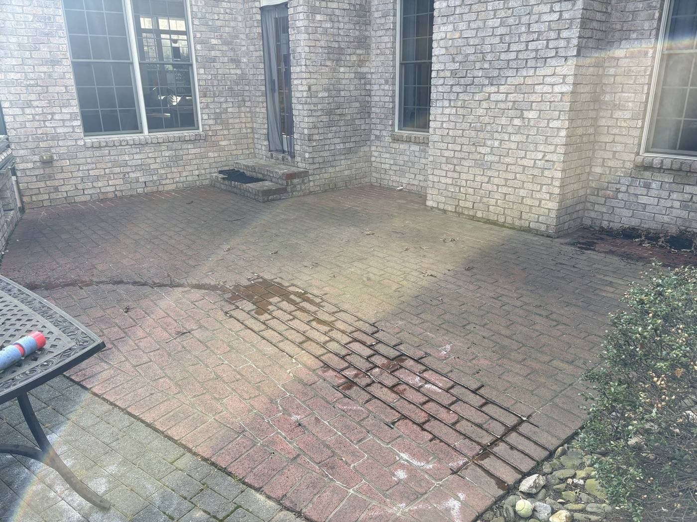 Brick patio with dirt and buildup before pressure washing