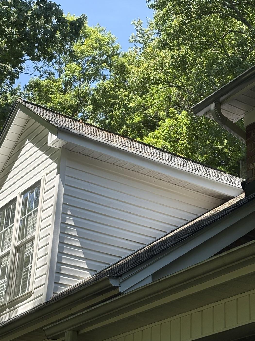 The same dormer siding clean and bright white after a soft wash