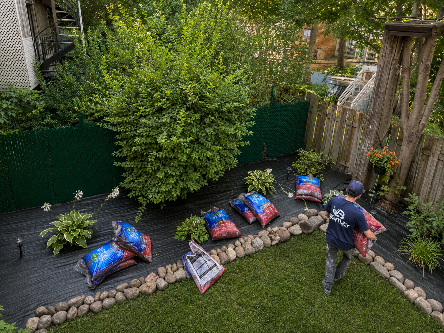 Garden bed installation with stone border and fresh soil in a Montreal backyard