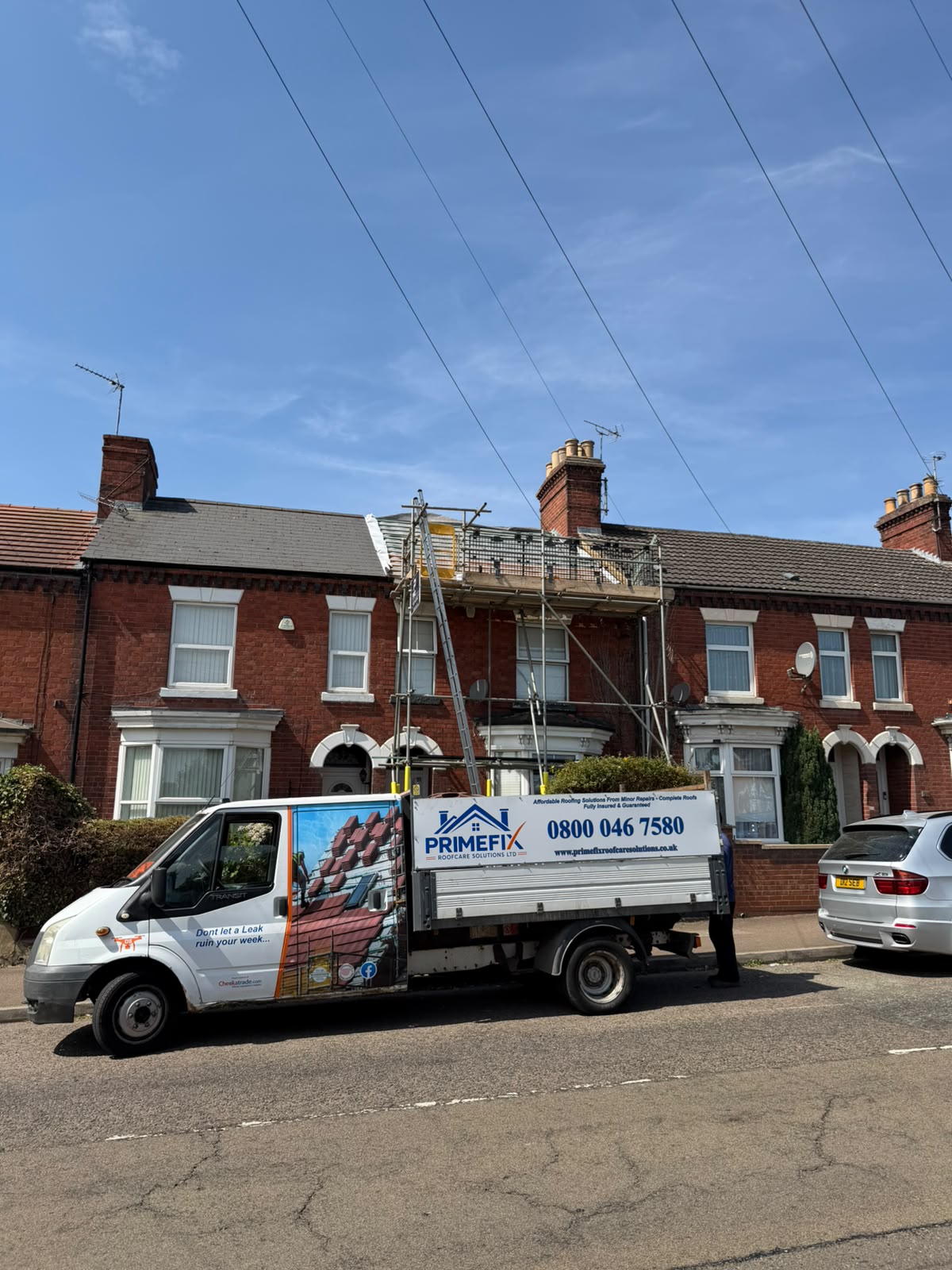 Primefix Roofcare commercial vehicle and scaffolding outside terraced property during roof replacement