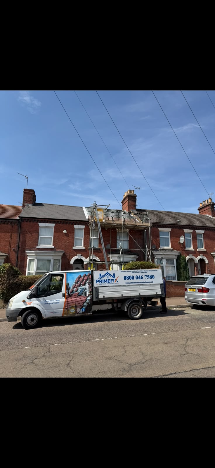 Scaffolding platform and Primefix vehicle outside terraced home during re-roofing