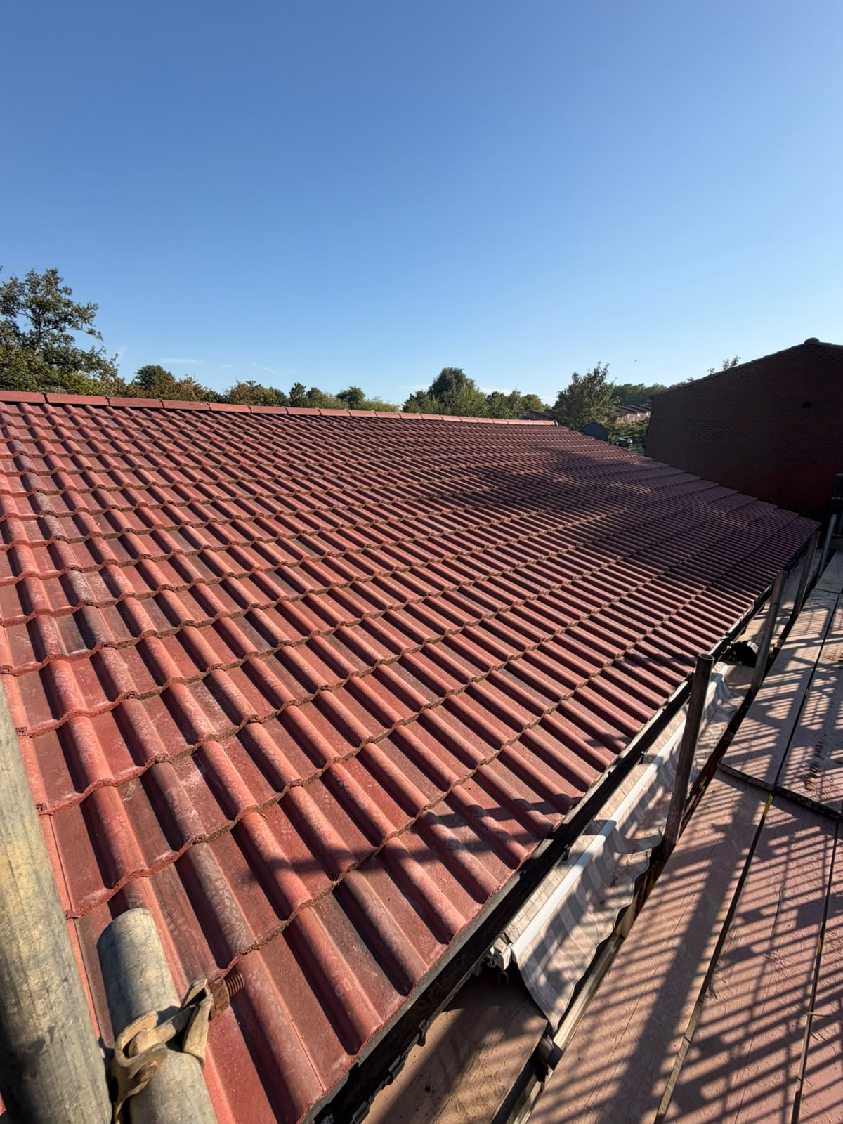 Large red Roman profile concrete tiled roof installation with dry ridge system