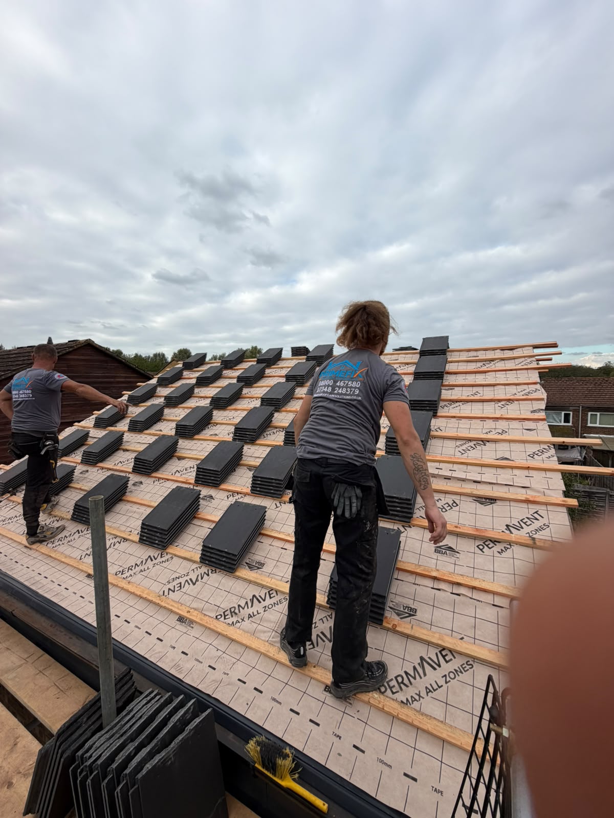 Primefix roofers loading roof tiles onto timber battens and breathable membrane