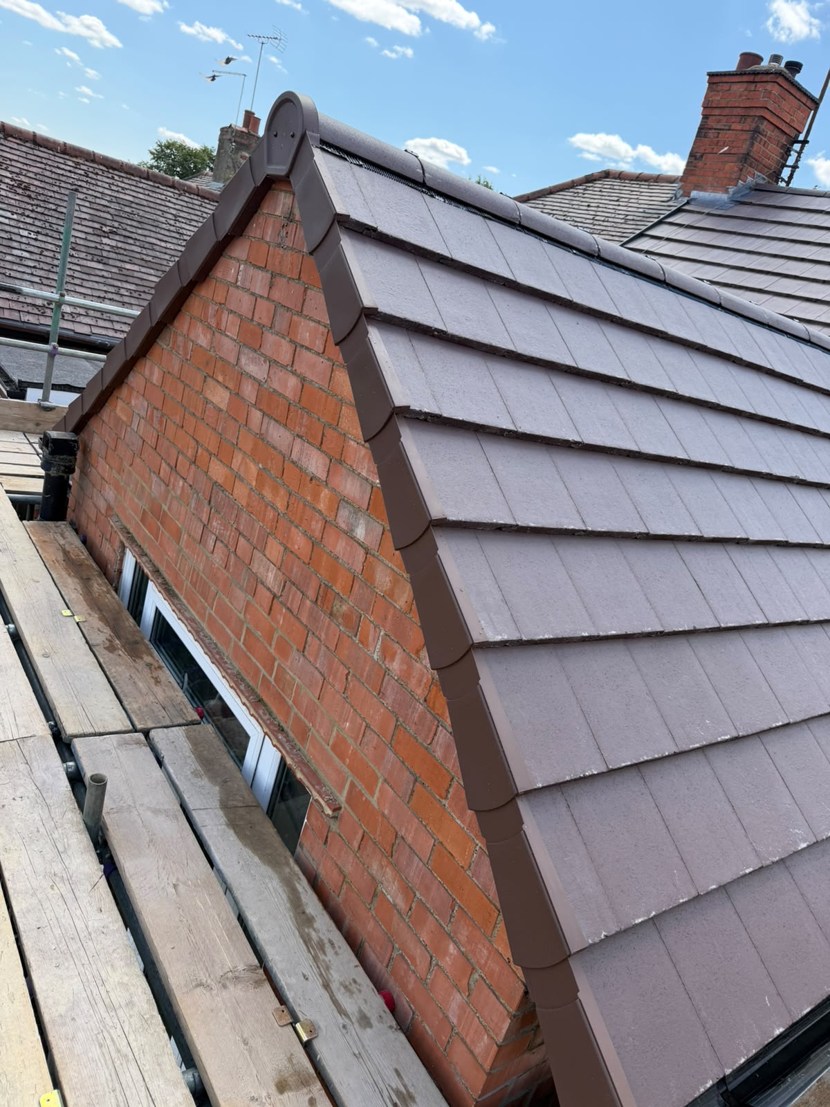 Dry verge system and interlocking tile installation on brick gable extension