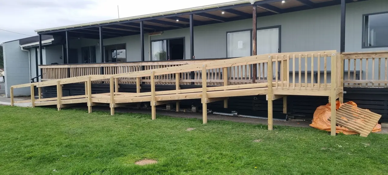 Accessible Timber Ramp - Completed gentle-incline timber wheel chair access ramp with safety handrails for accessible entry.