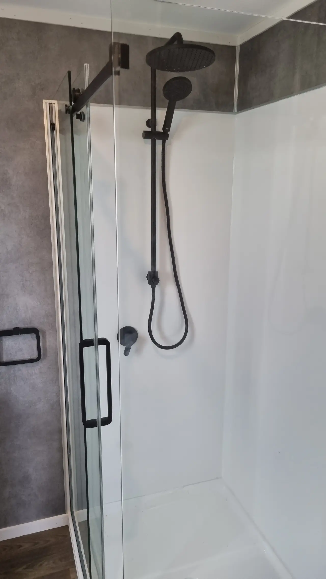 Modern Ensuite Renovation - Glass shower enclosure with matte black handles and shower fittings.