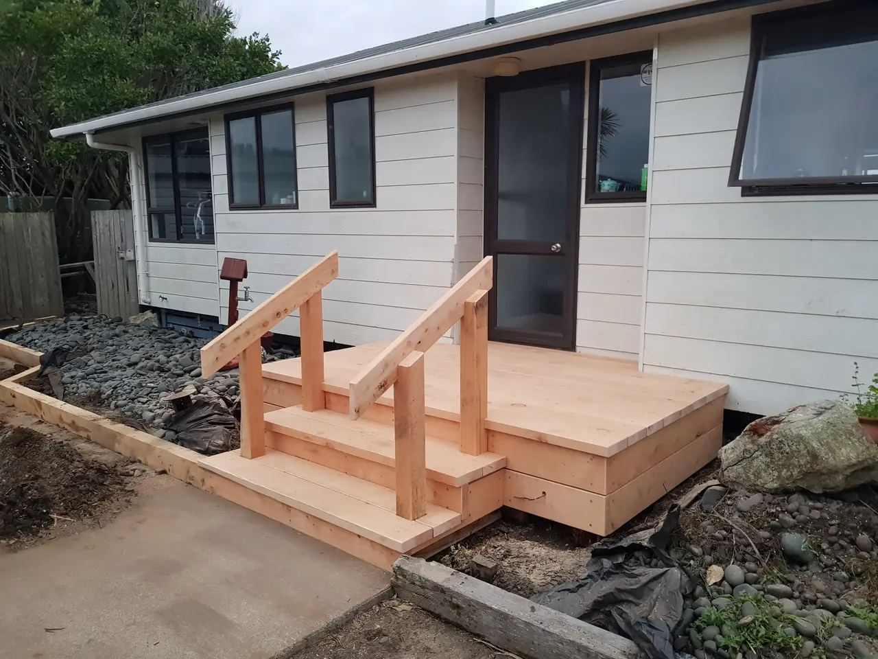 Small Timber Entry Deck with Steps - Completed small macrocarpa timber entry deck with 3 steps and handrails leading up to the doorway.
