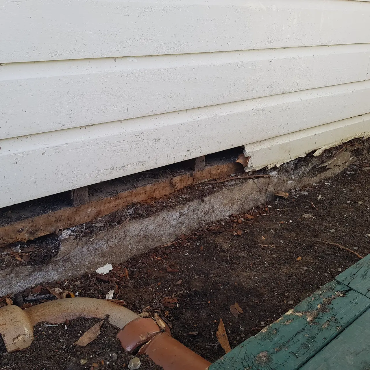 General Maintenance - Close-up of the damaged foundation showing visible cracks and debris from the failed section.