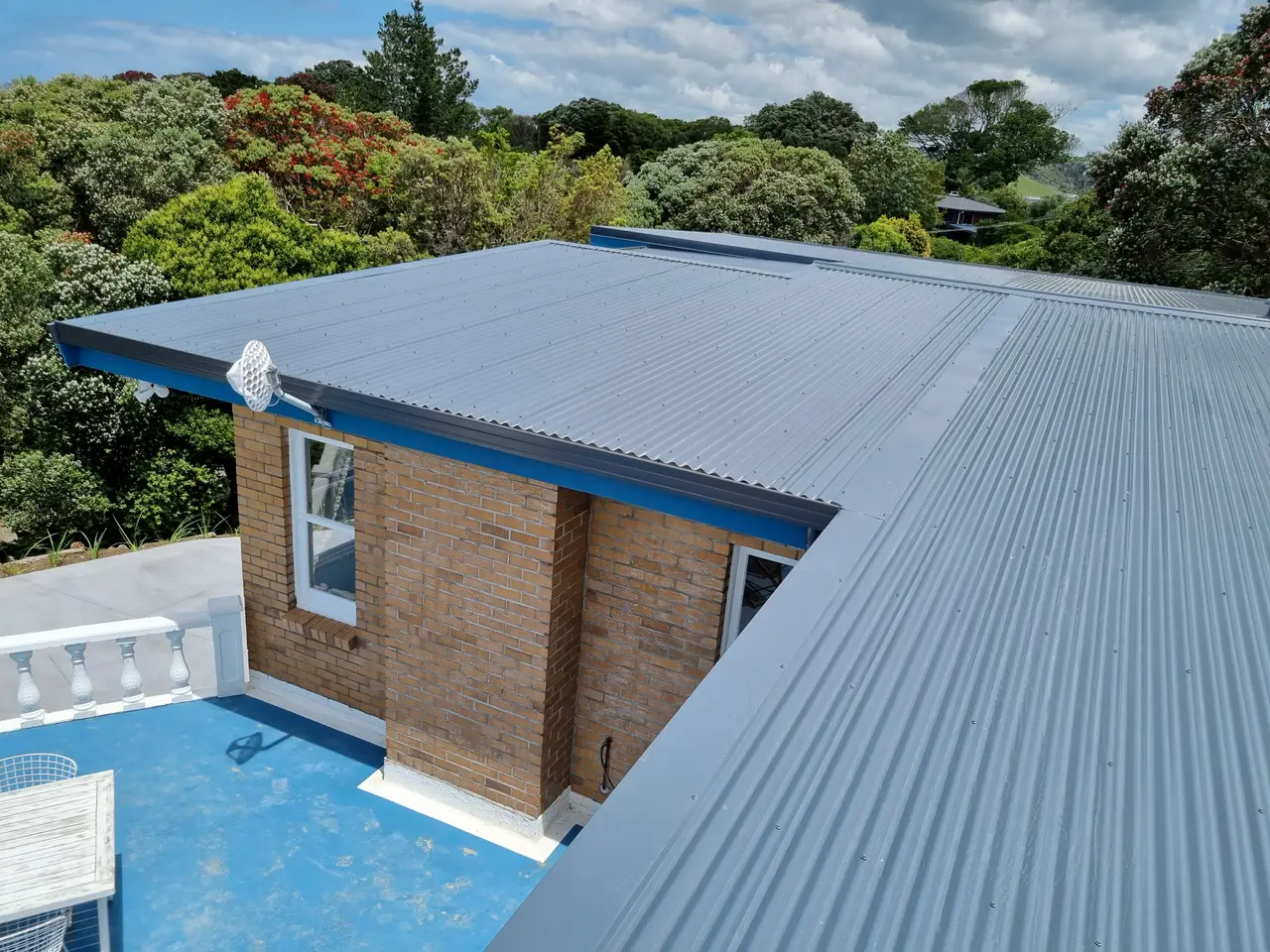 Roofing - Finished edge and gutter detail, iron and flashing meeting cleanly at the eaves.