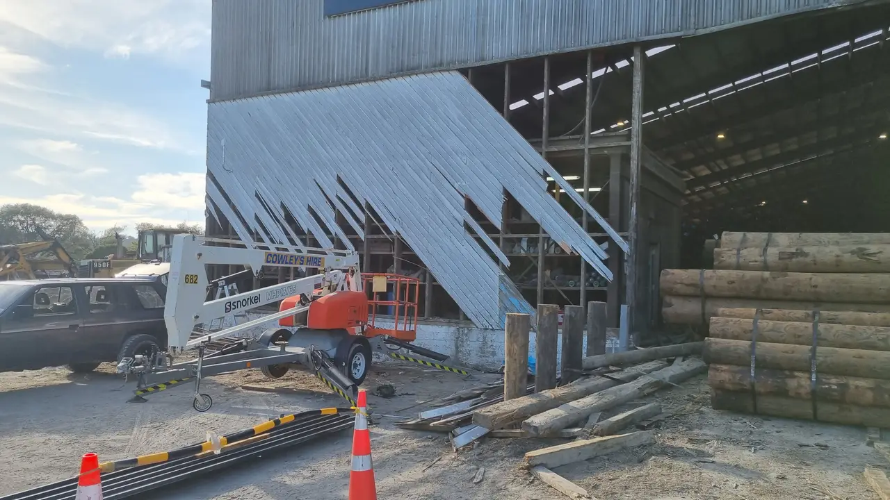 General Maintenance - The damaged section of broken exterior cladding before removal, with a hired lift on site for safe overhead access.