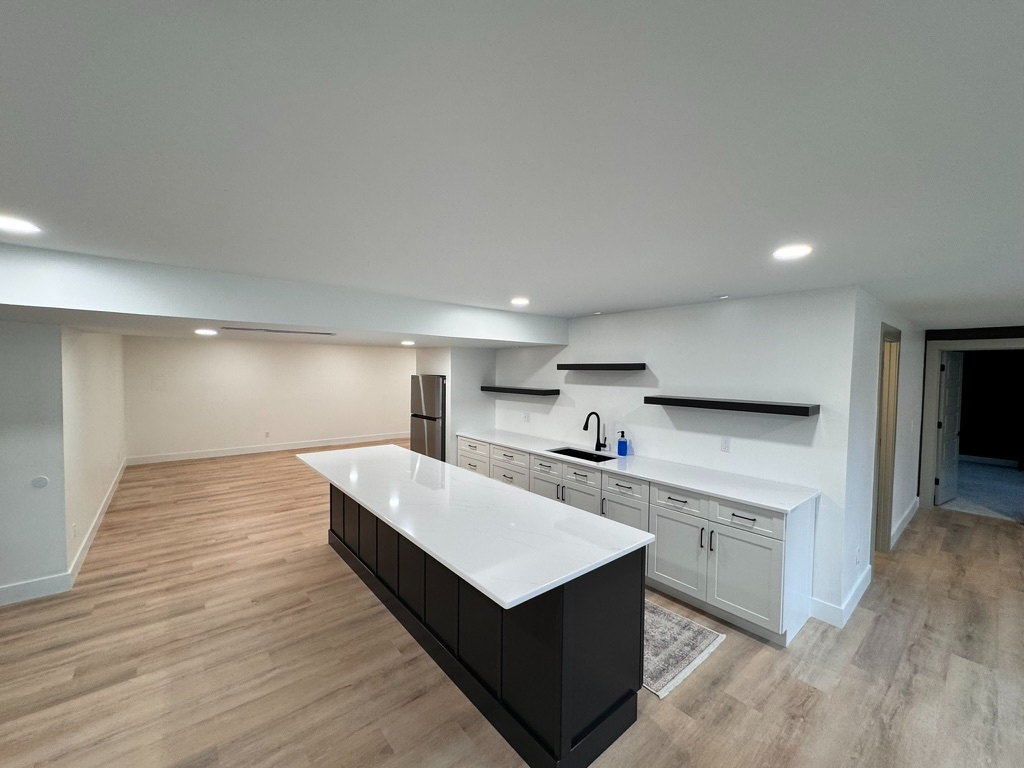 Executive basement bar with quartz island and matte black cabinetry in Cincinnati