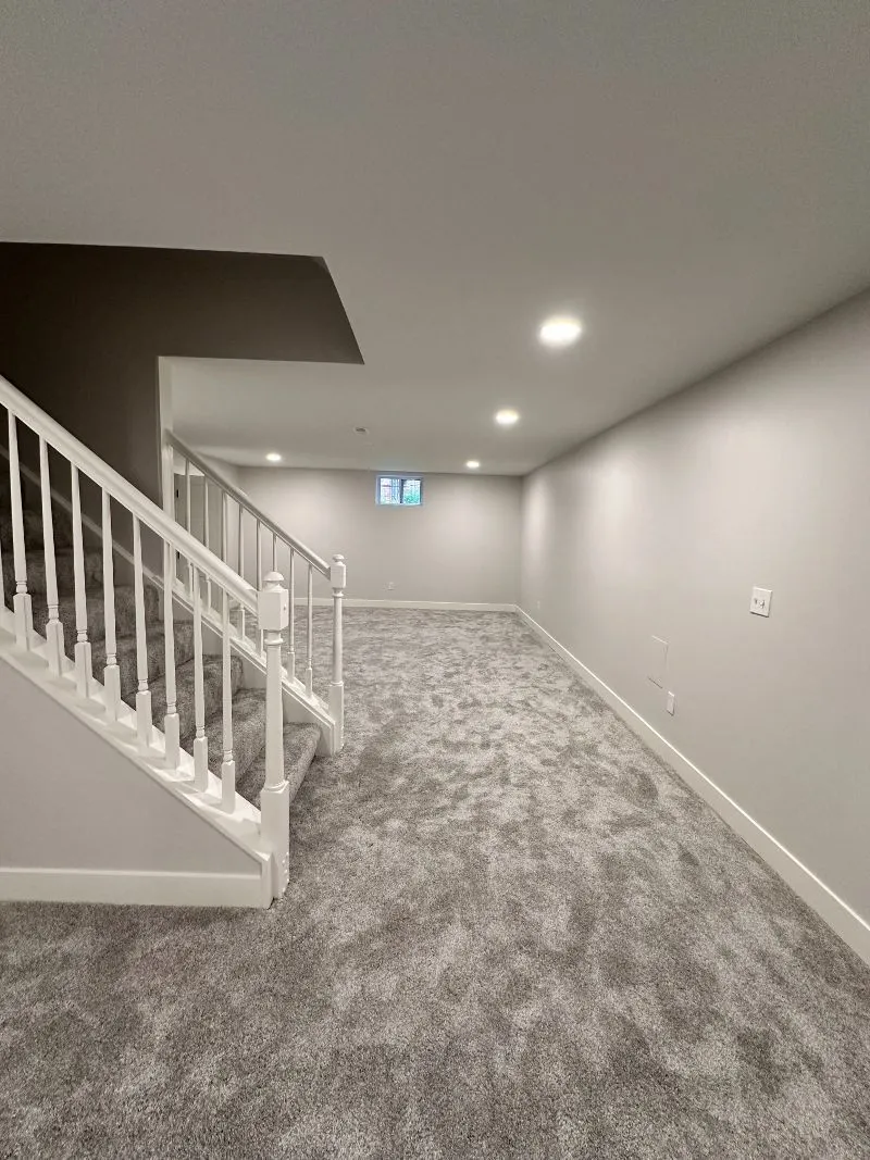 Finished basement with custom open staircase and plush carpeting in Cincinnati
