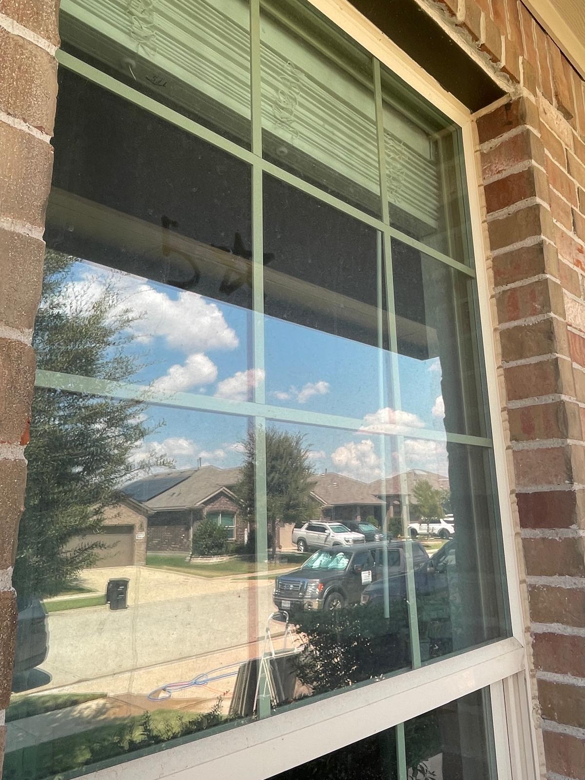 Residential brick home window with cloudy grime and water spots before cleaning