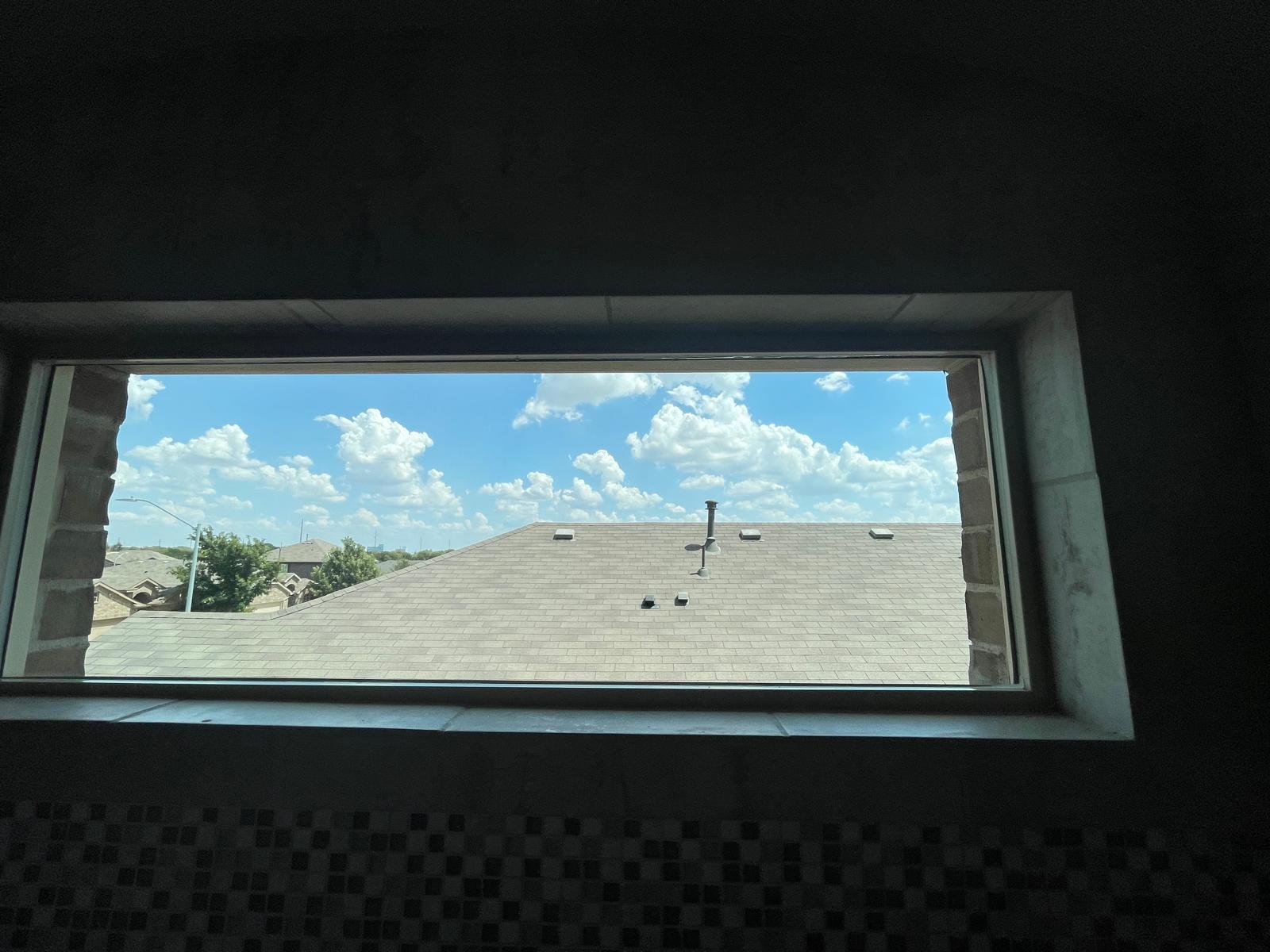 Interior view of clerestory window crystal clear overlooking blue sky and rooftop after professional cleaning
