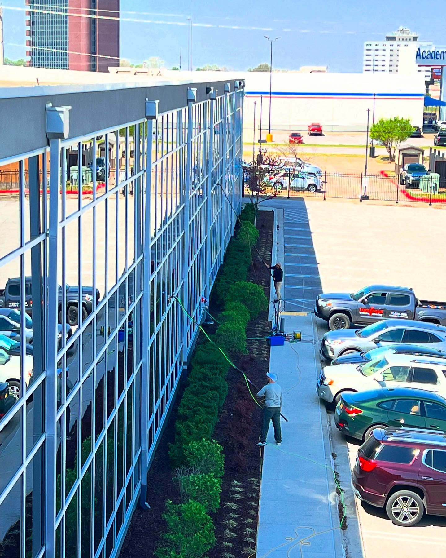 Two technicians cleaning commercial building windows