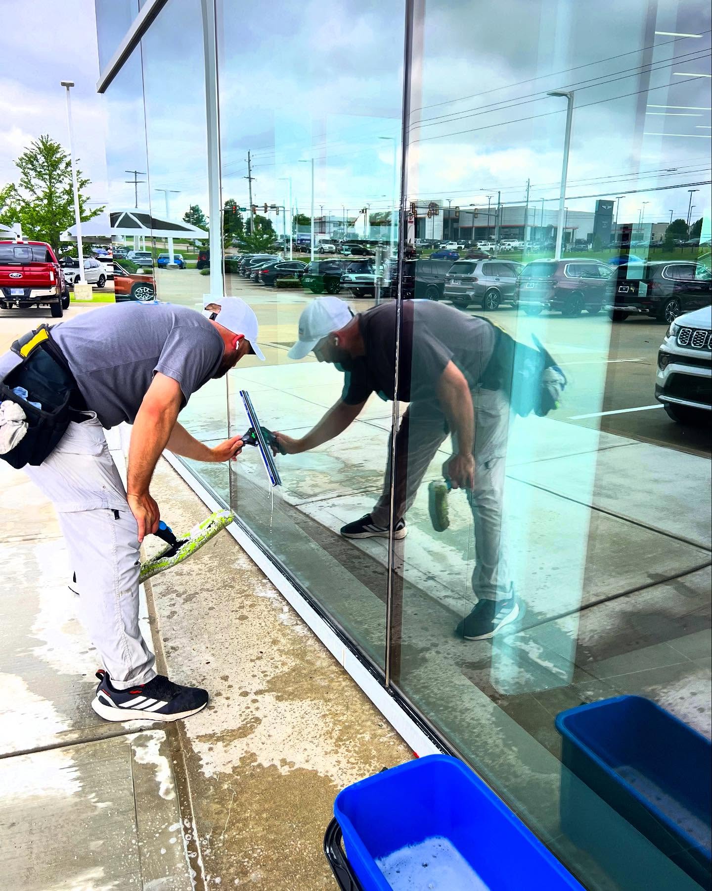 Two Luminous team members cleaning commercial storefront windows