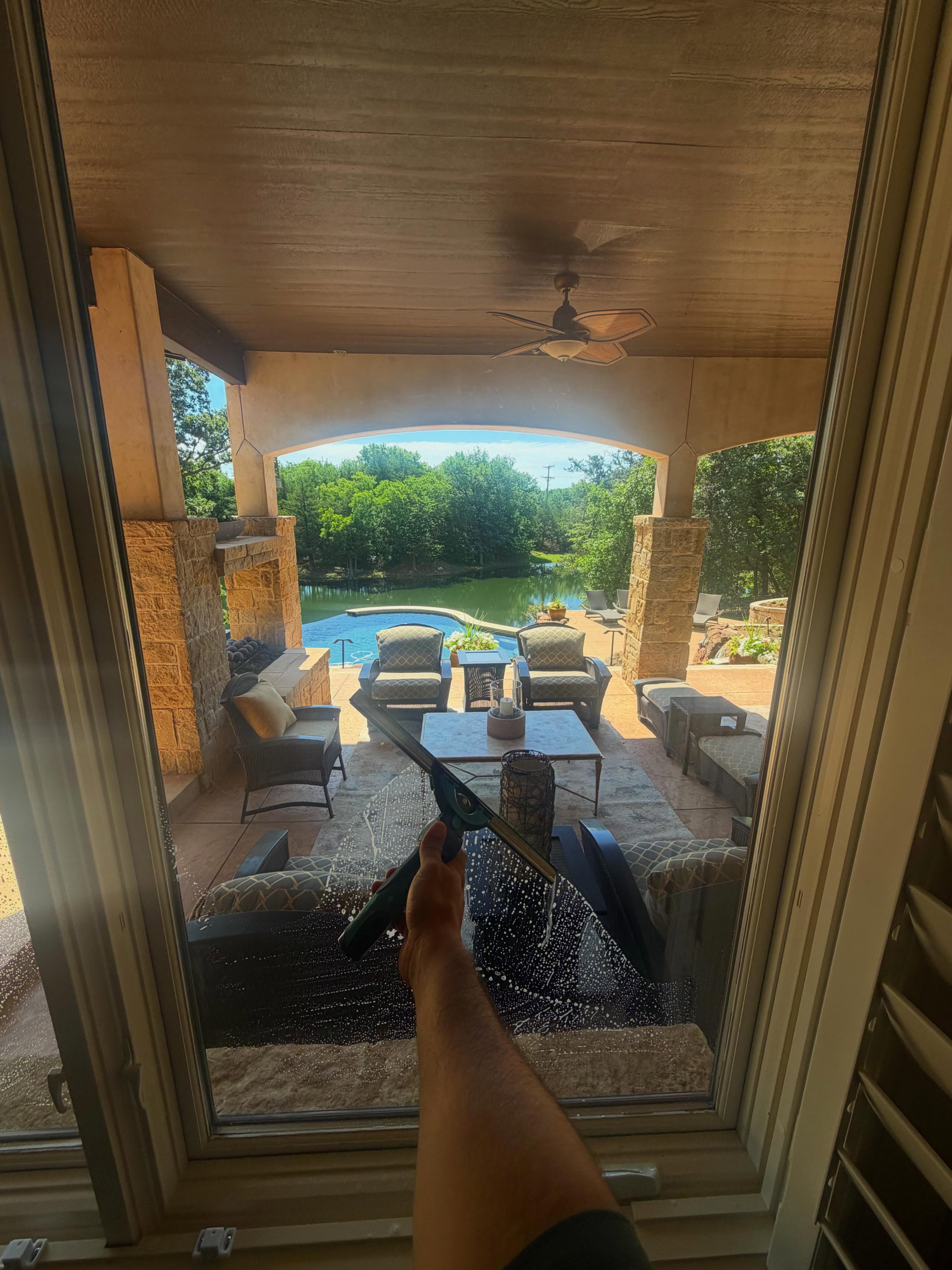 Cleaning large glass doors overlooking pool patio