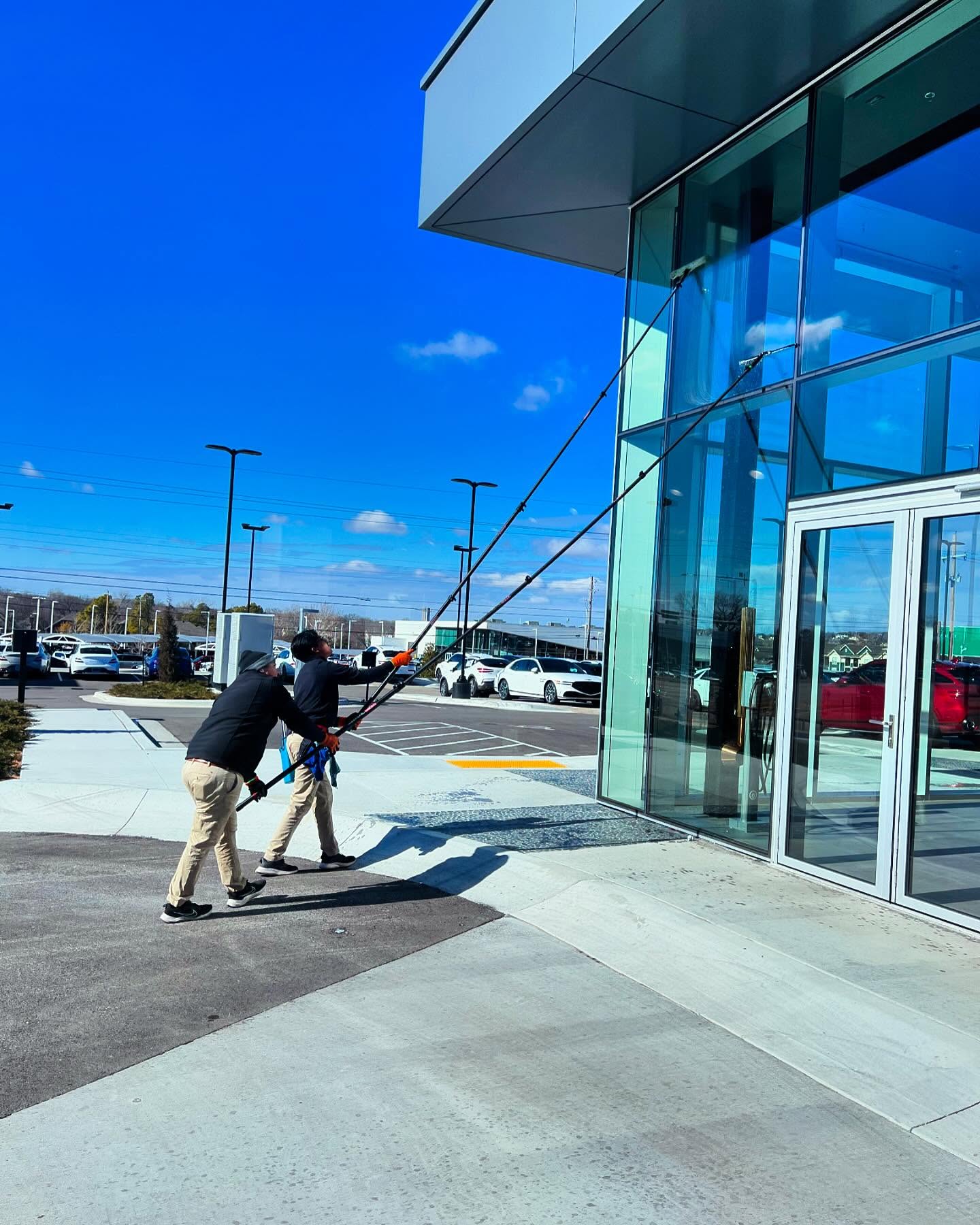 Two technicians cleaning modern glass office building