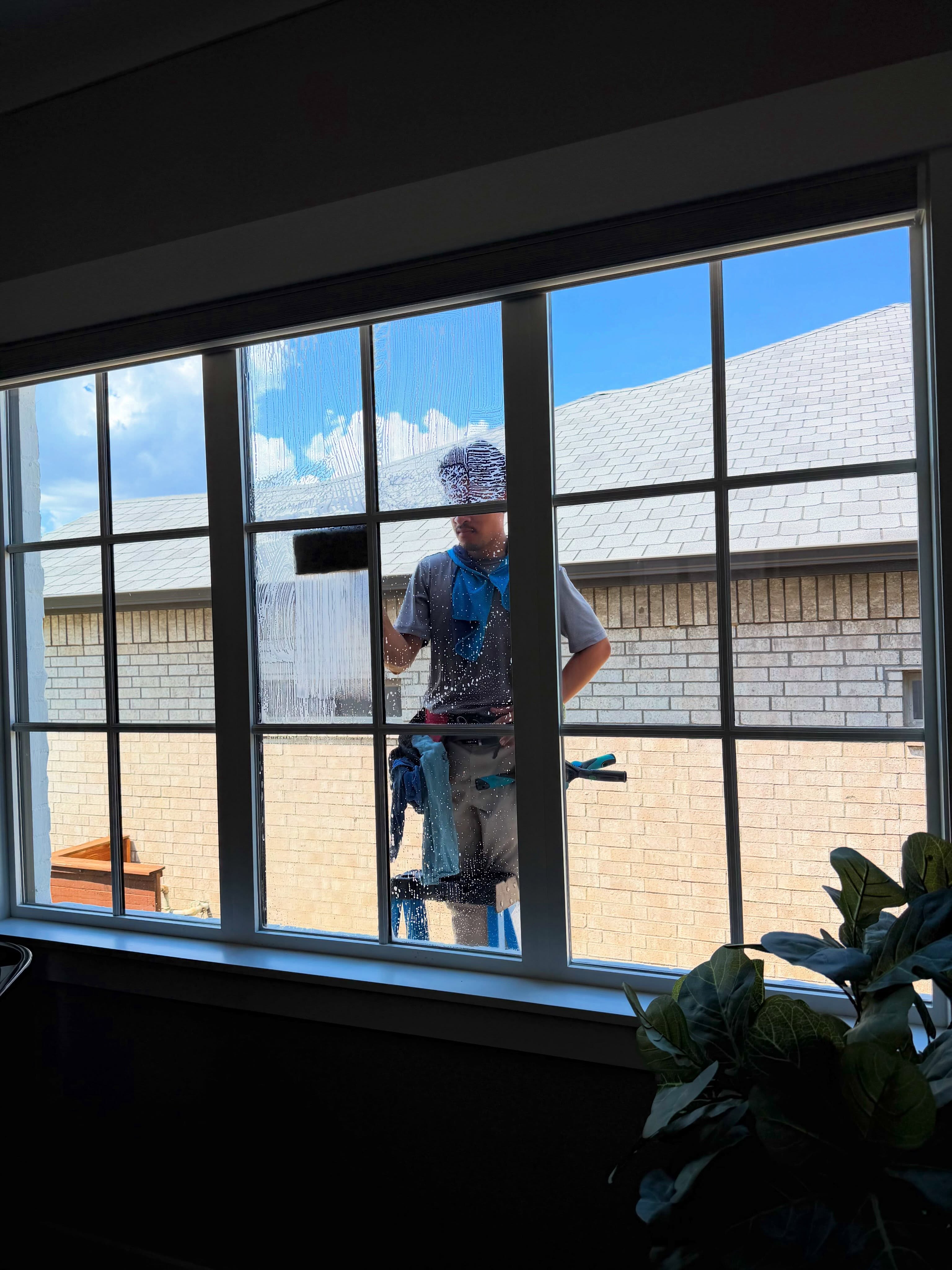Luminous team member cleaning residential windows
