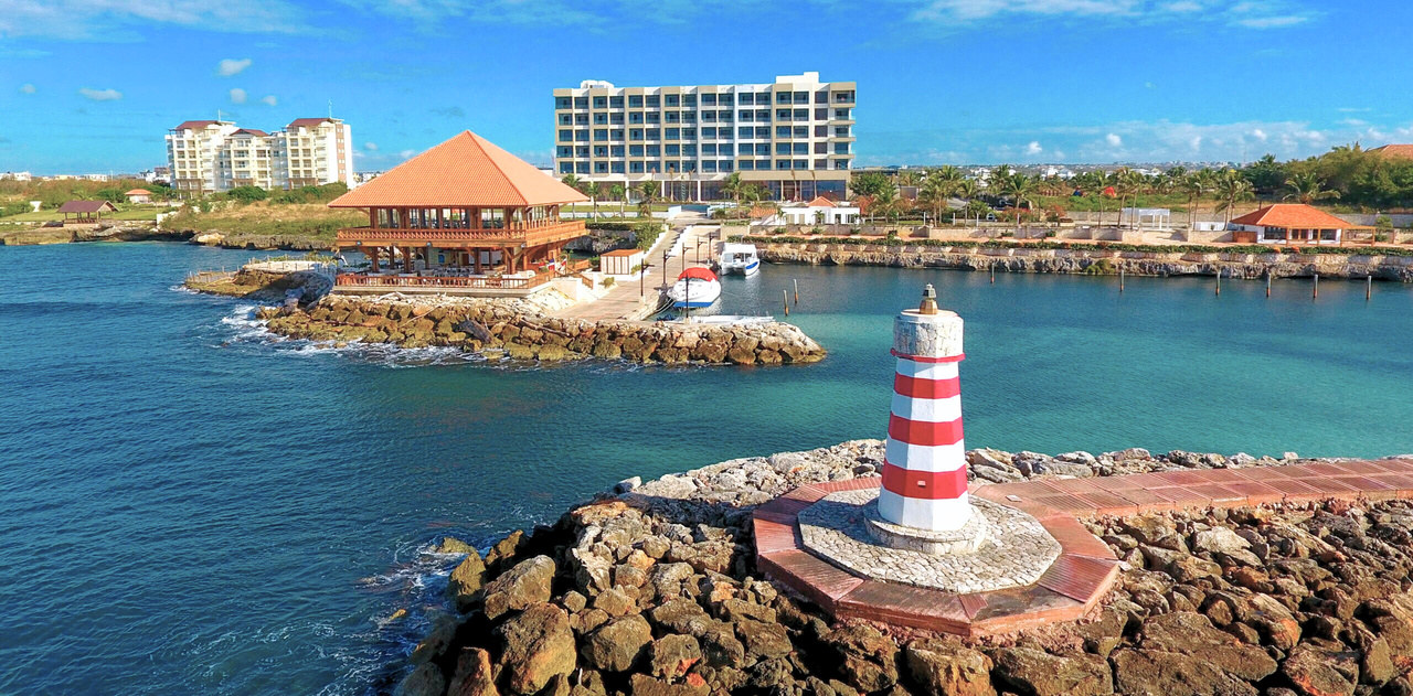 Vista costera de La Caleta, La Romana, con el faro, el mar y la costa
