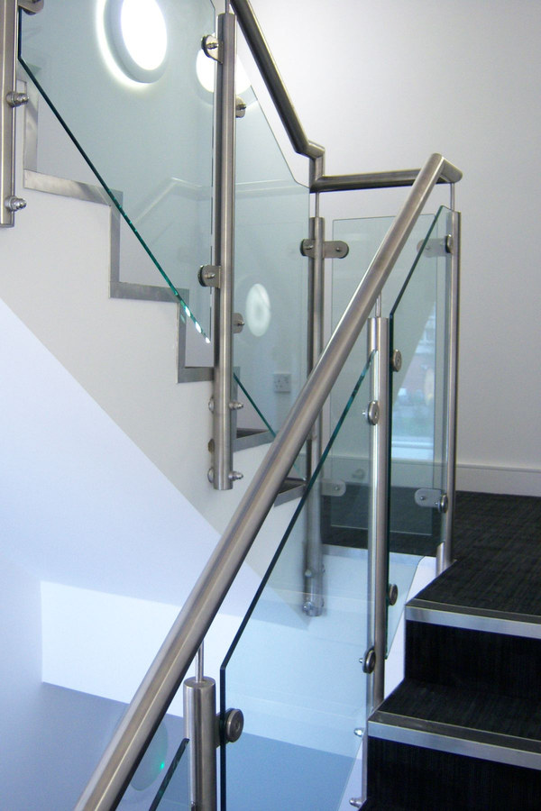 Detalle de escaleras con pasamanos de acero inoxidable y cristales templados