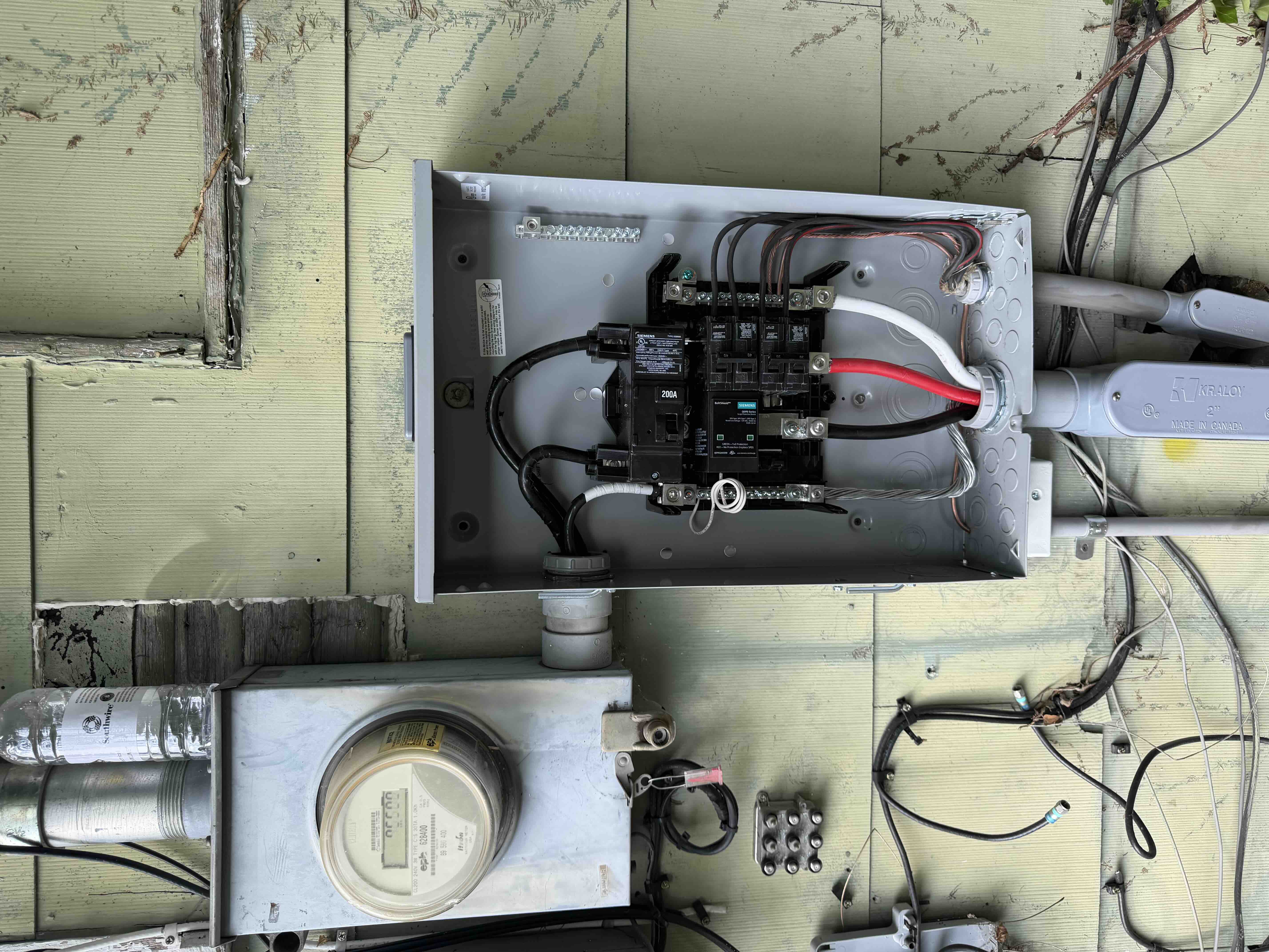 Siemens 200A outdoor main disconnect meter combo panel with integrated surge protection device installed next to an electric utility meter