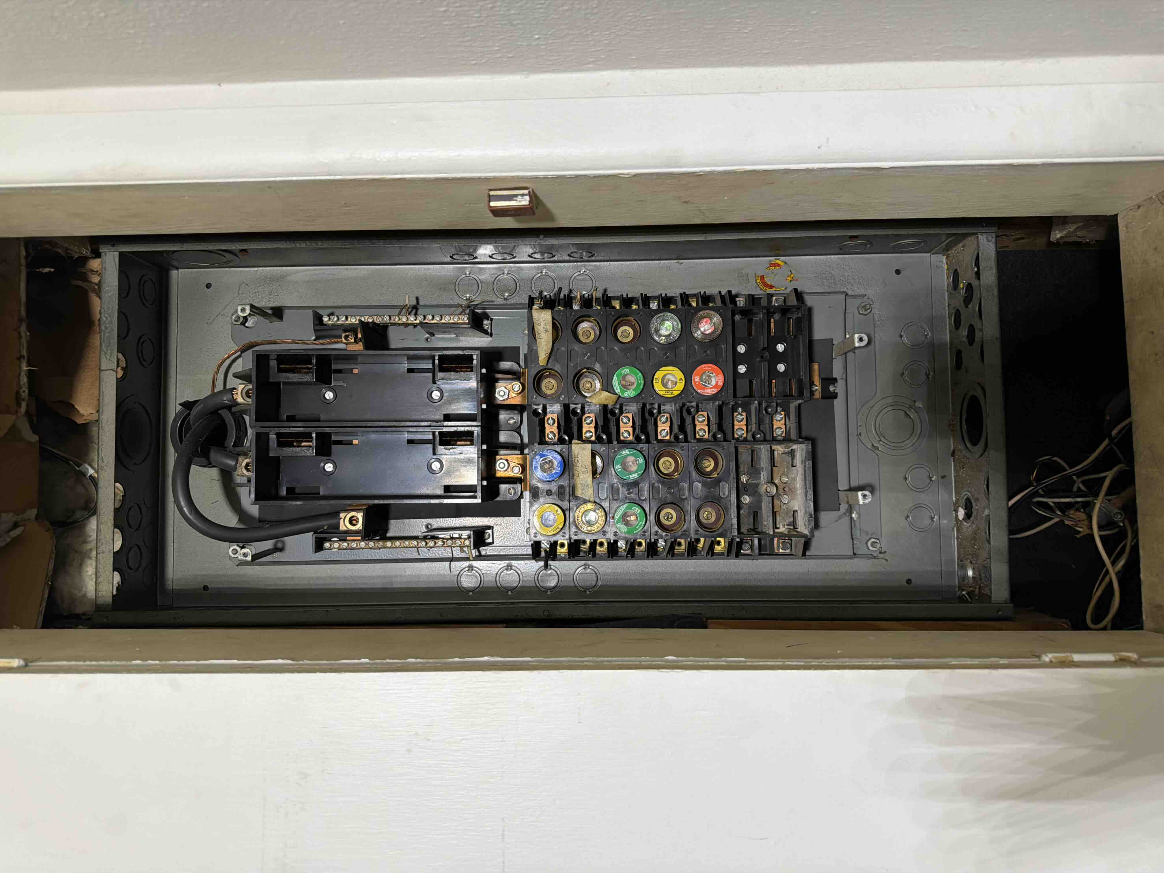 Empty electrical panel box with fuse blocks removed, prepped for a new breaker panel installation