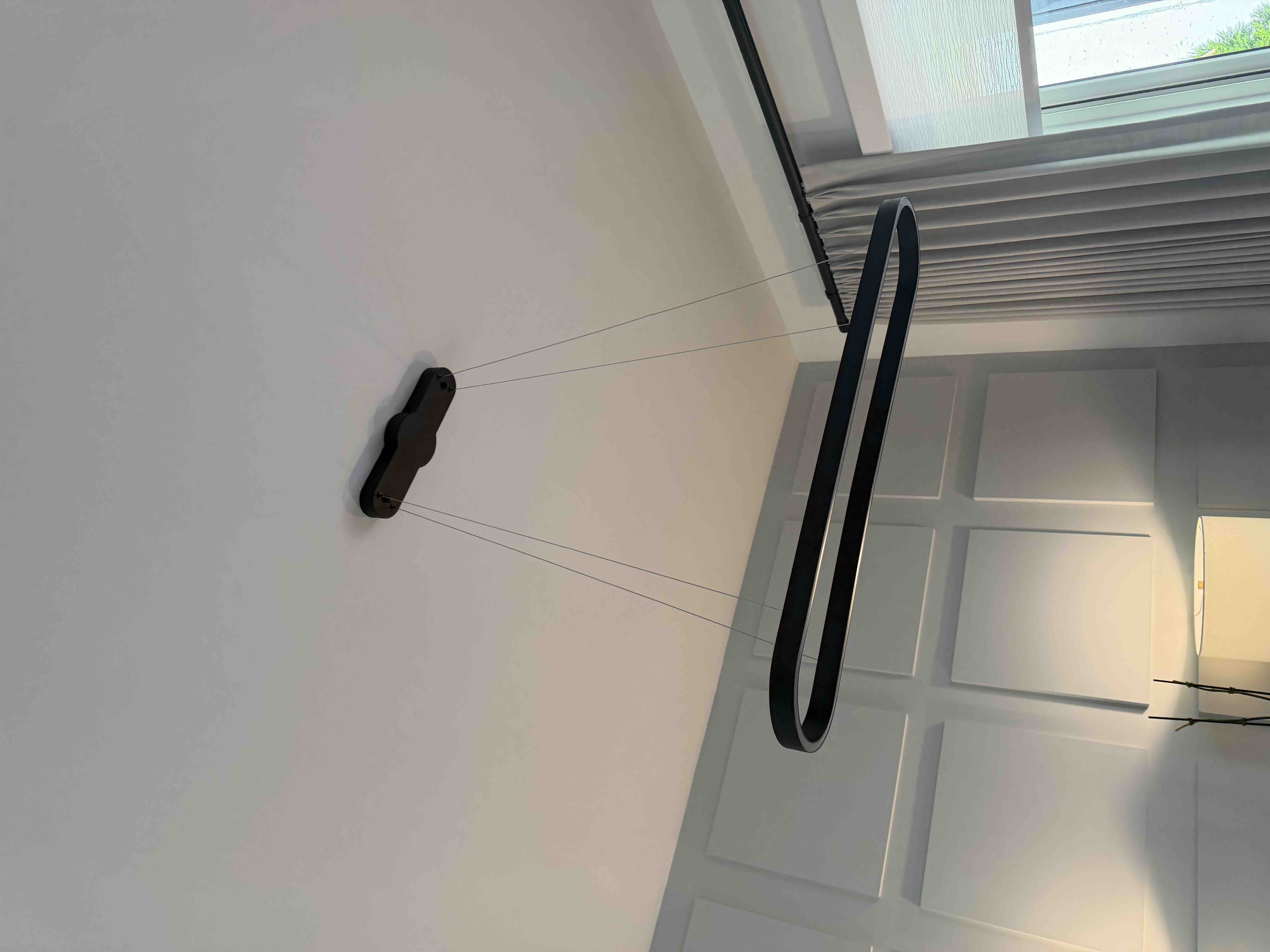 Linear oval black LED ring pendant light floating from slender suspension wires