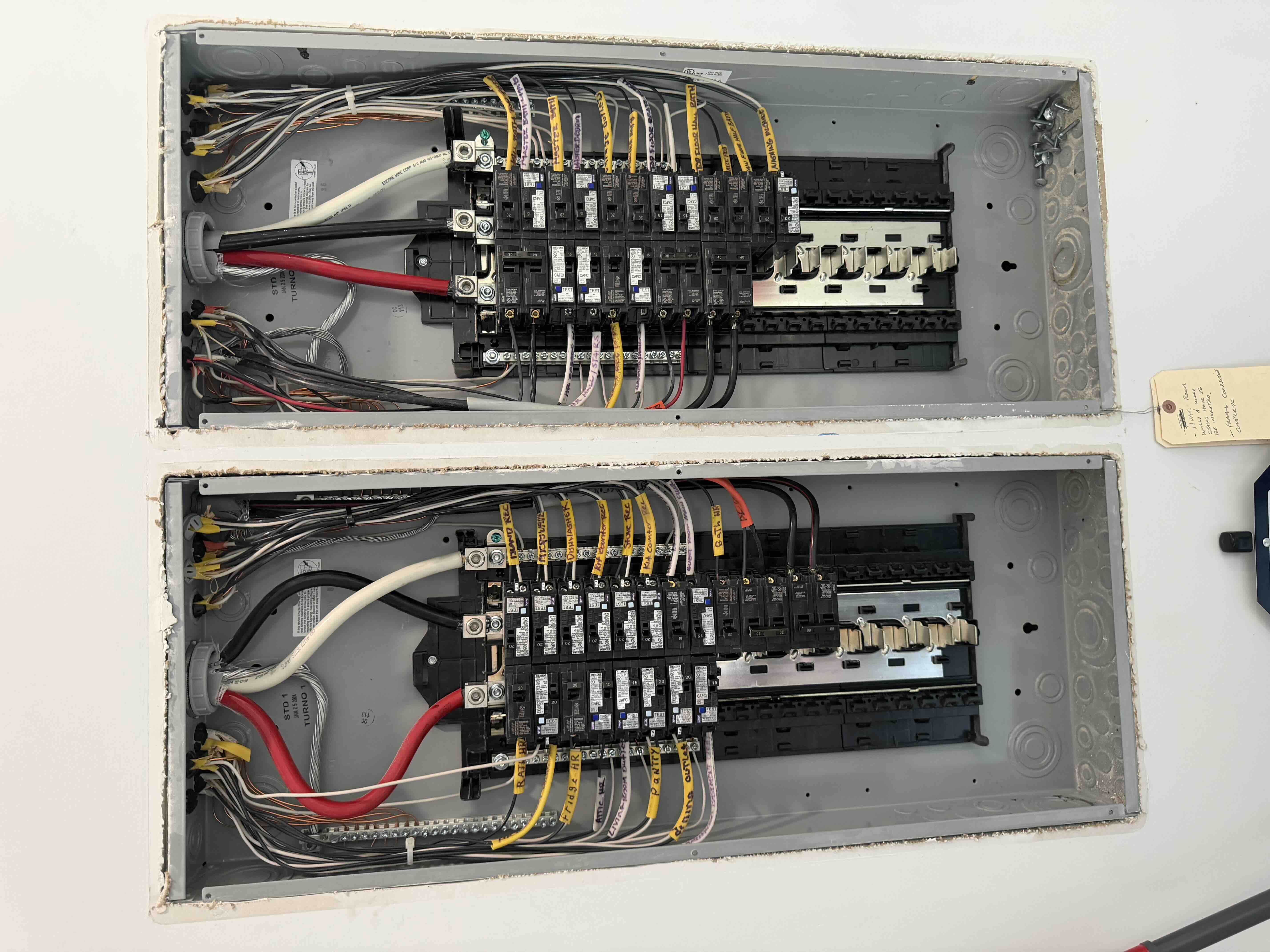 Open dual breaker panels with every circuit wire clearly tagged and labeled by room during installation
