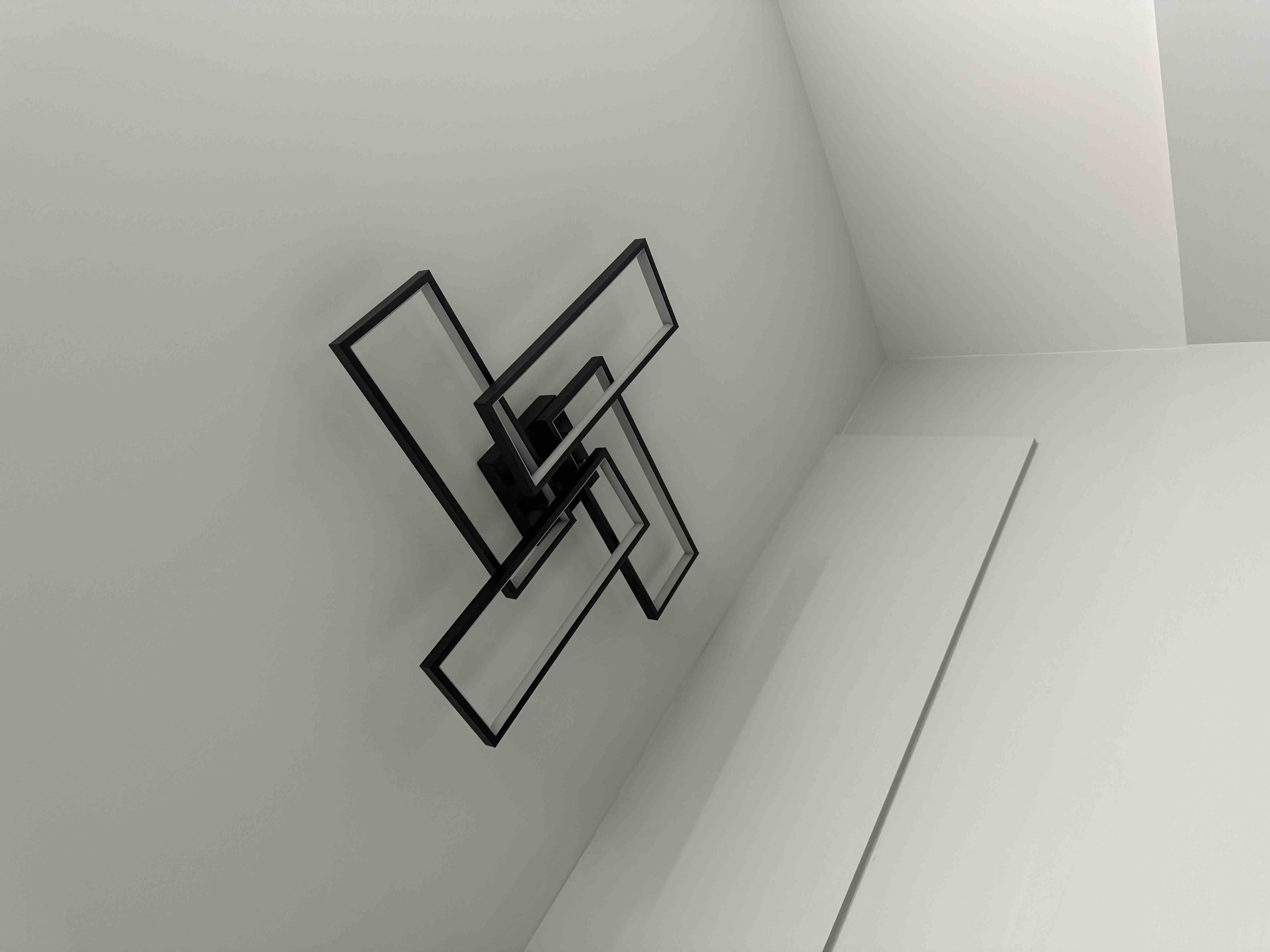 Modern black geometric pinwheel LED wall and ceiling light fixture installation