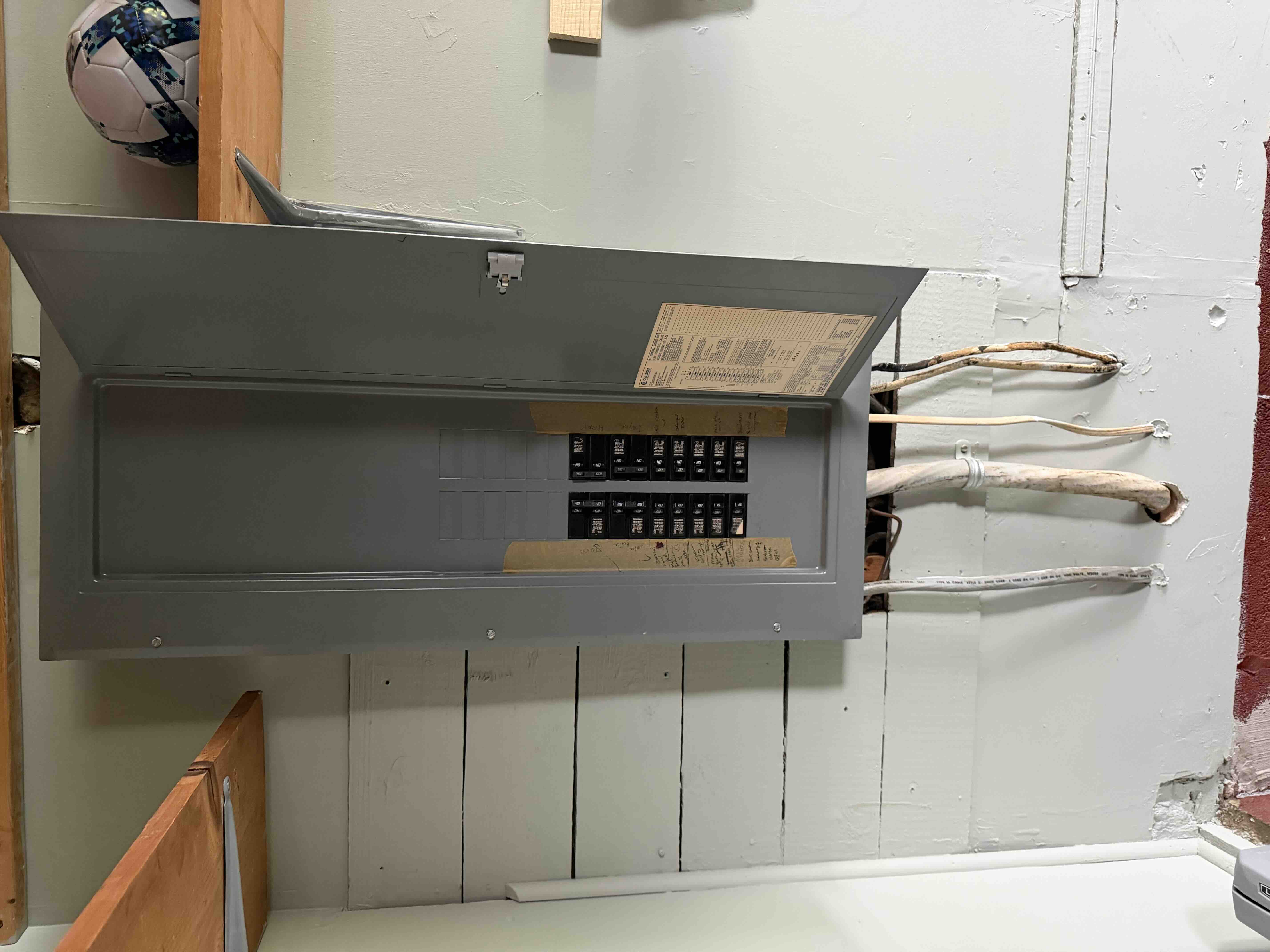 Outdated residential breaker panel with door open prior to service upgrade and replacement
