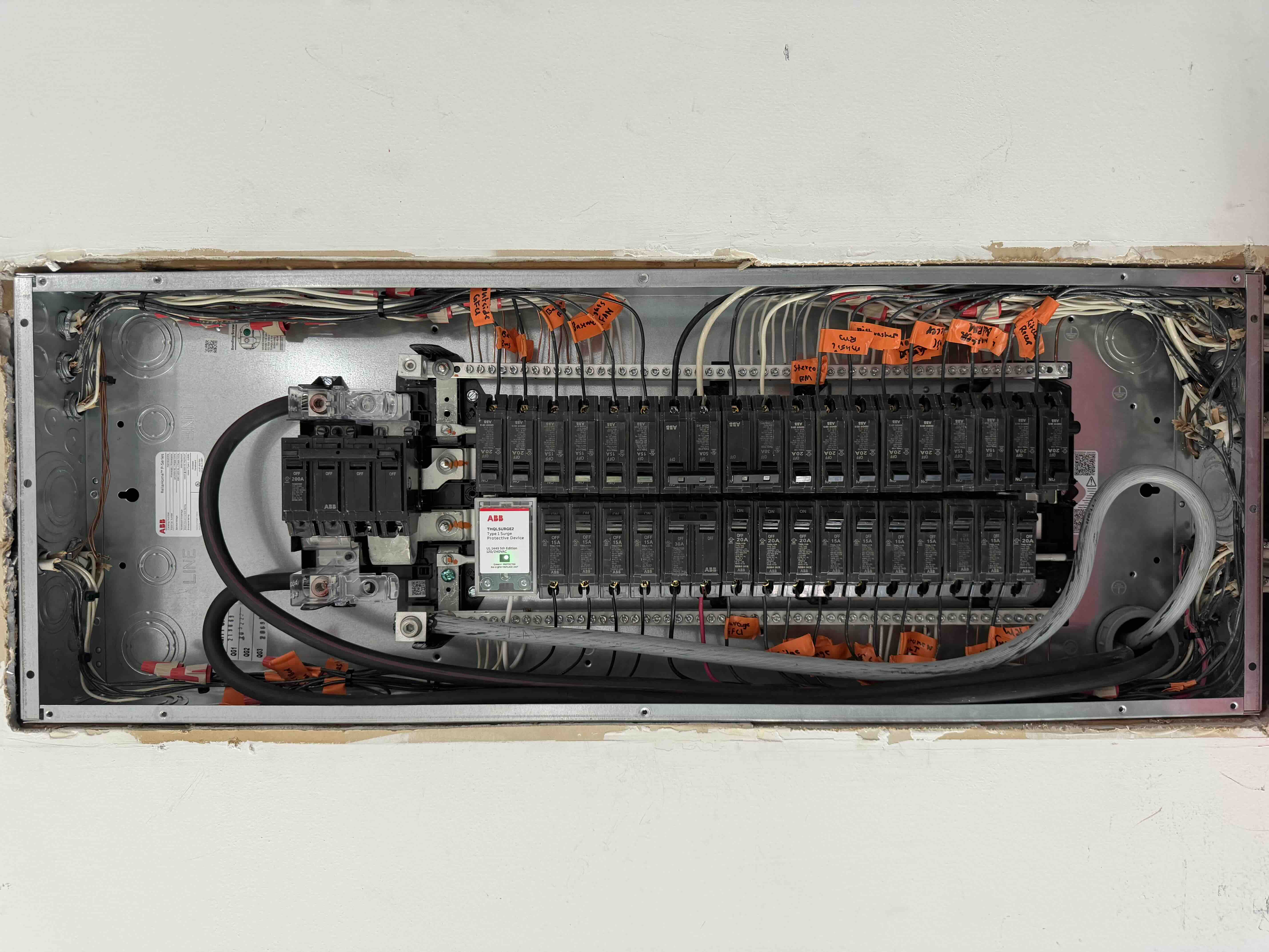 Close view of a fully wired ABB breaker panel with rows of labeled circuit breakers and a Type 1 surge protective device