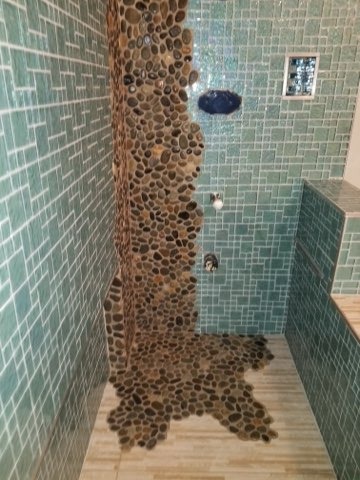 Pebble tile shower feature with teal mosaic walls installed by Level 4 Tile and Stone in San Diego