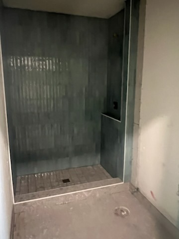 Dark gray vertical striated porcelain tile shower with built-in recessed niche by Level 4 Tile and Stone