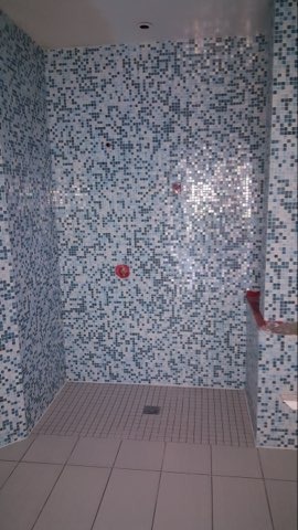 Blue dot mosaic shower walls with coordinating porcelain floor by Level 4 Tile and Stone San Diego