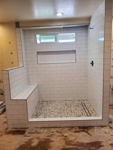 White subway tile curbless shower with bench and niche by Level 4 Tile and Stone San Diego