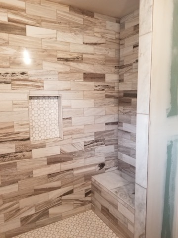 Wood look porcelain tile master bathroom with hexagon mosaic floor and custom niche installation