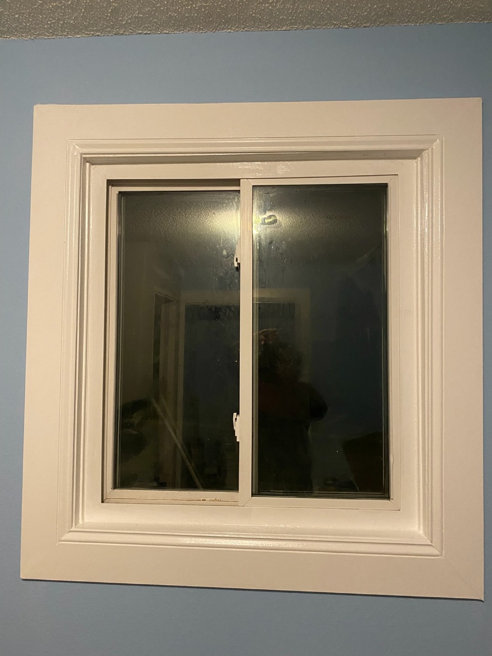 Window Trim — Crisp White Frame Against Blue Wall