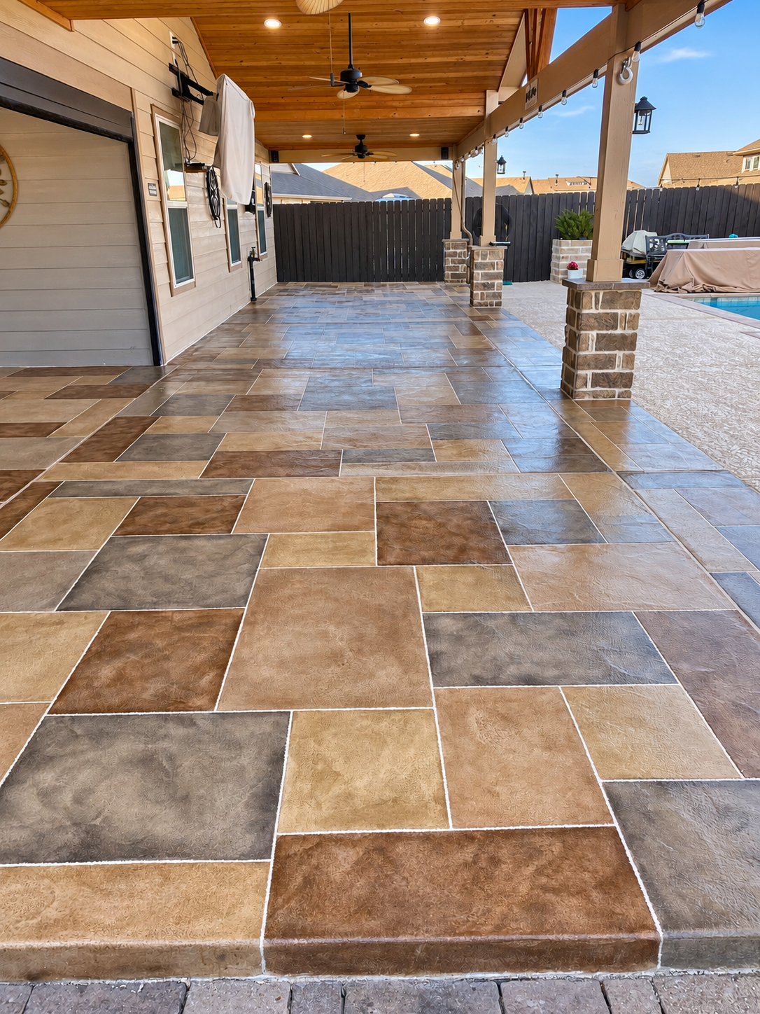 Finished residential outdoor patio flooring with custom warm stone-cut pattern in Houston
