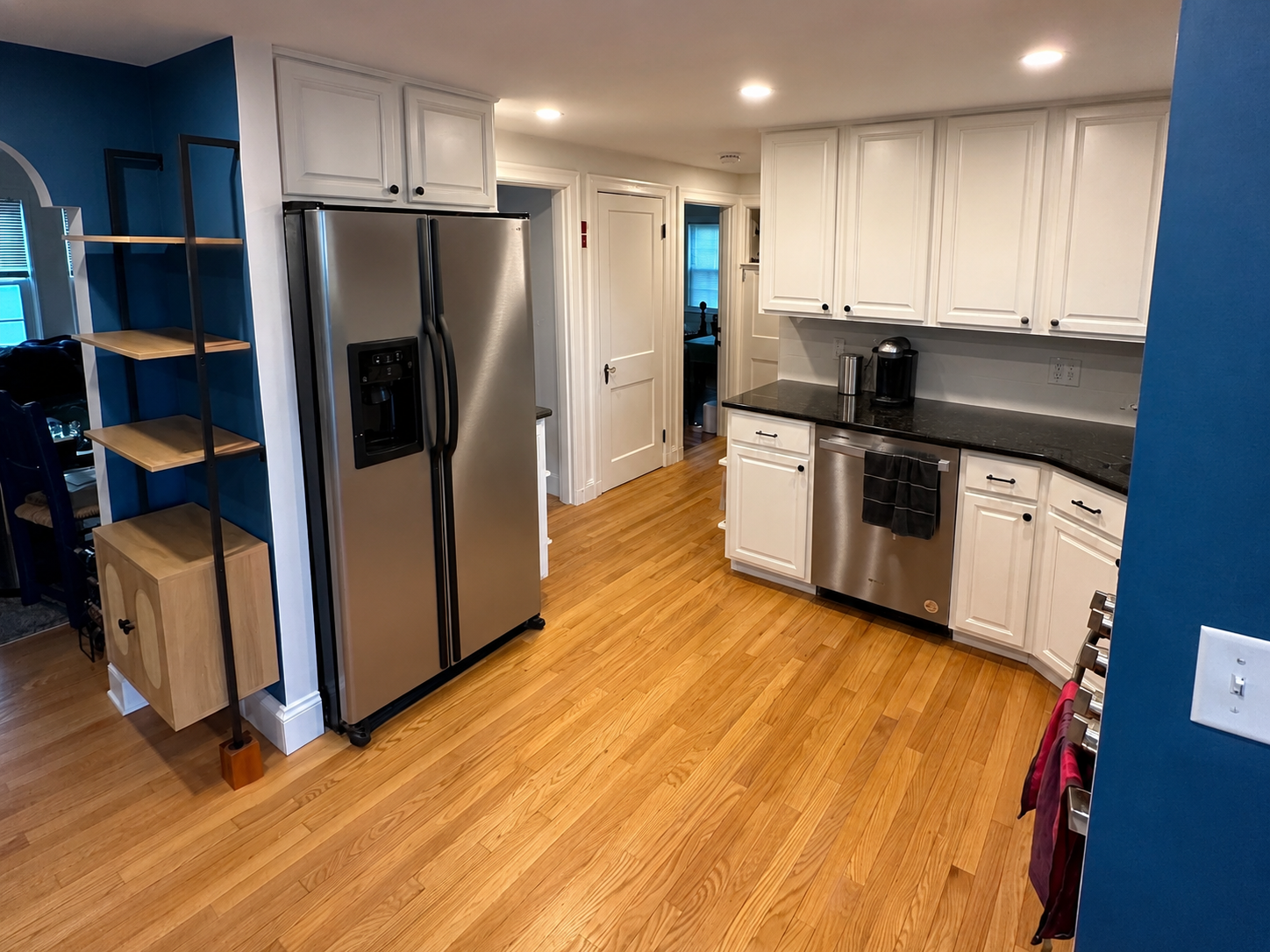 Cabinet painting — freshly painted kitchen with white cabinets and a blue accent wall in Sterling MA